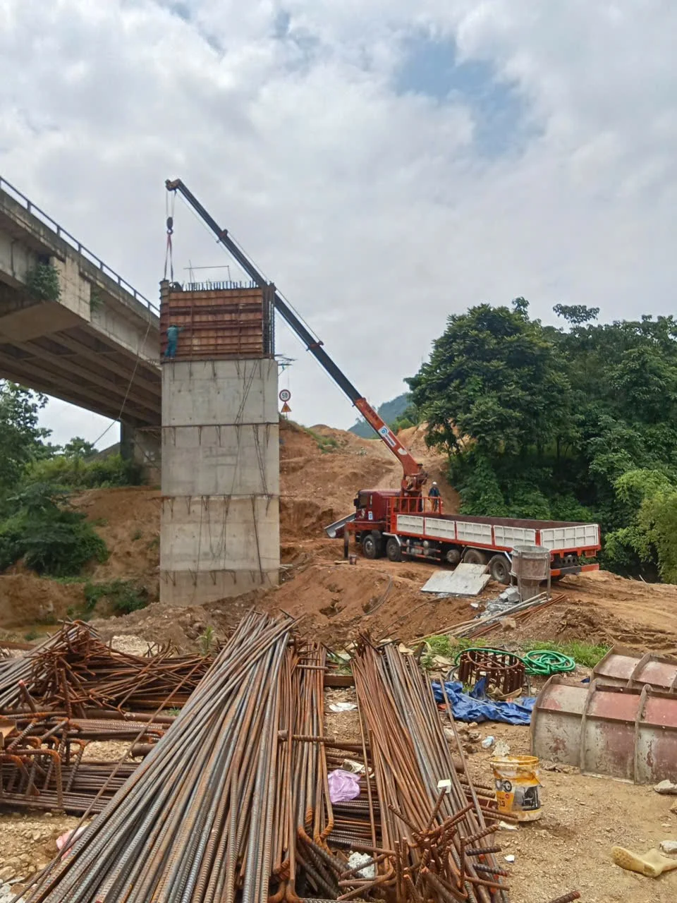 Cẩu thi công lắp dựng trụ cầu tại công trường